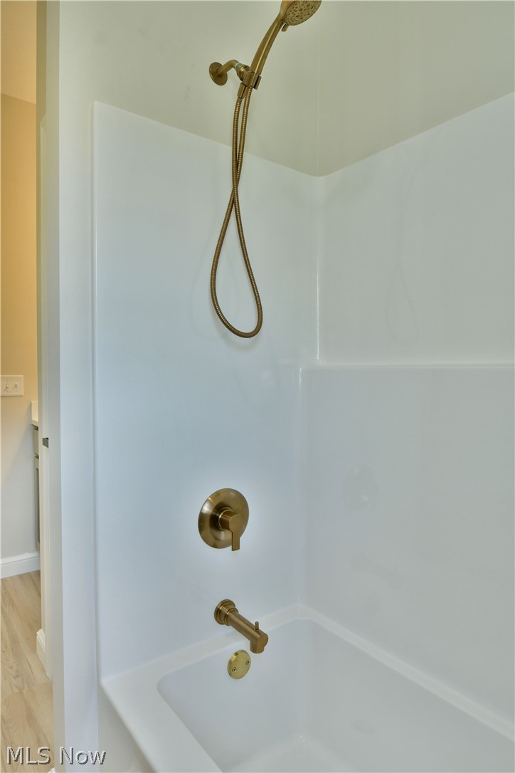 4780 State Rte 5 Cortland, OH 44410 - Photo 34 of 50 White bathtub with a bronze-finish shower system, including a handheld showerhead and coordinating fixtures