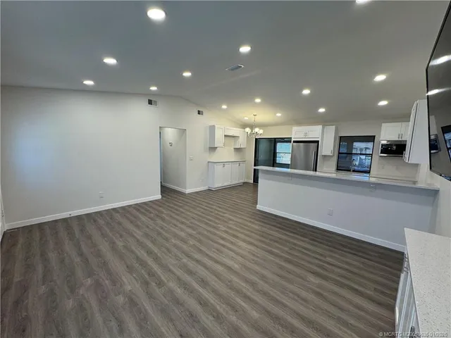 a view of a kitchen with a sink and a refrigerator
