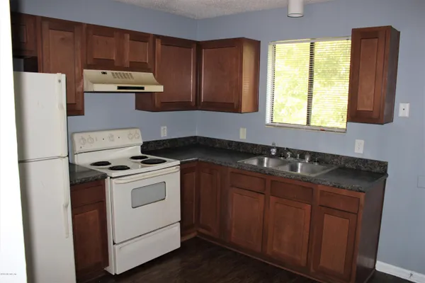 a kitchen with a stove a sink and a window