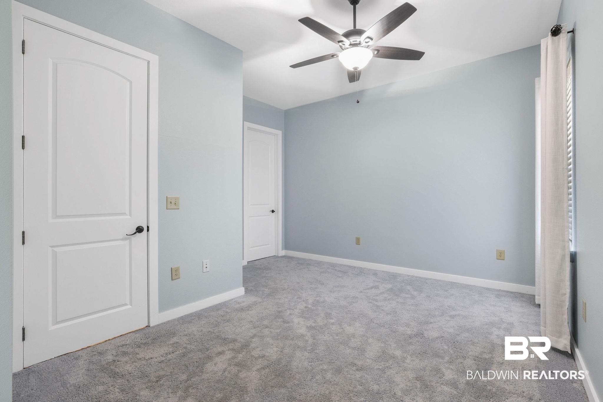 1430 Regency Road, Unit B302 Gulf Shores, AL 36542 - Photo 11 of 24 Unfurnished bedroom with a ceiling fan, baseboards, and carpet floors