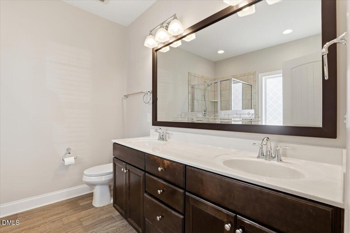 157 Ramsgate Drive Clayton, NC 27520 - Photo 19 of 42 a bathroom with a granite countertop sink a toilet and a mirror