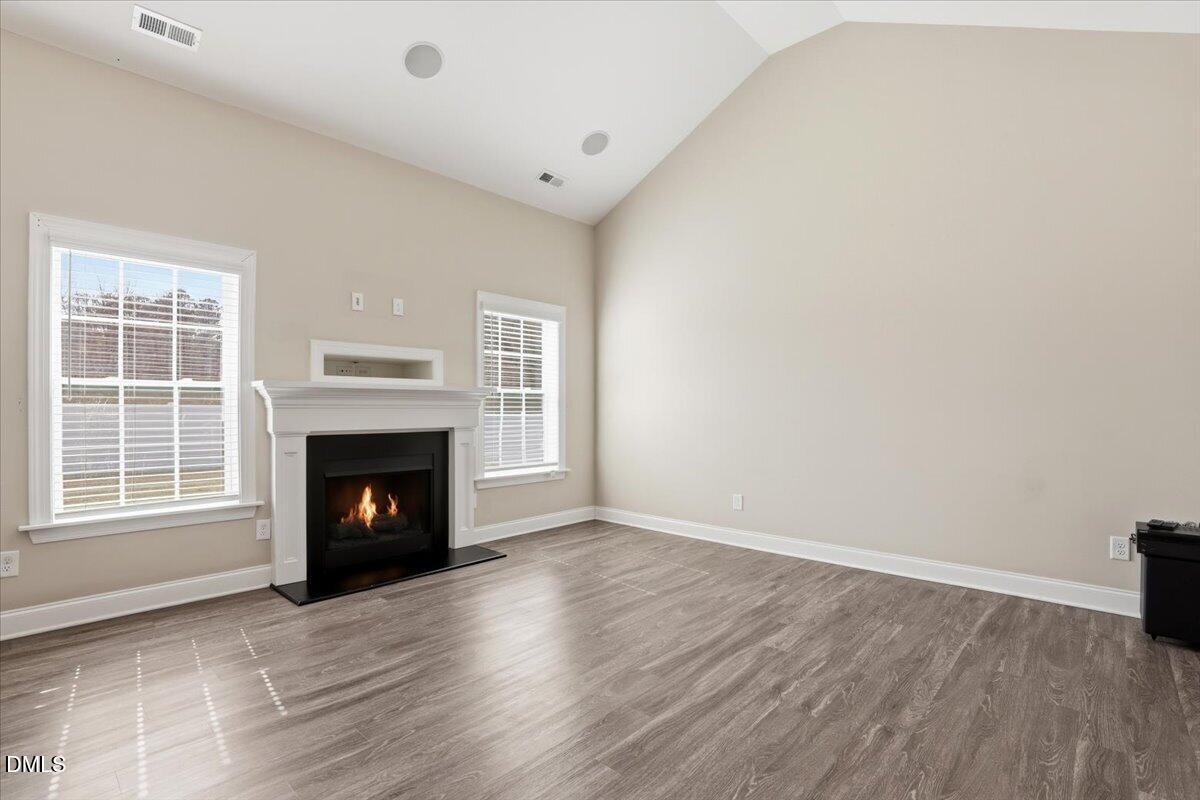 157 Ramsgate Drive Clayton, NC 27520 - Photo 7 of 42 a view of an empty room with wooden floor fireplace and a window