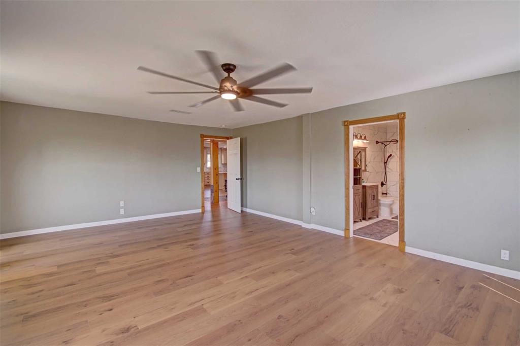 3559 Springfield Road Springtown, TX 76082 - Photo 12 of 37 a view of an empty room with wooden floor and a ceiling fan