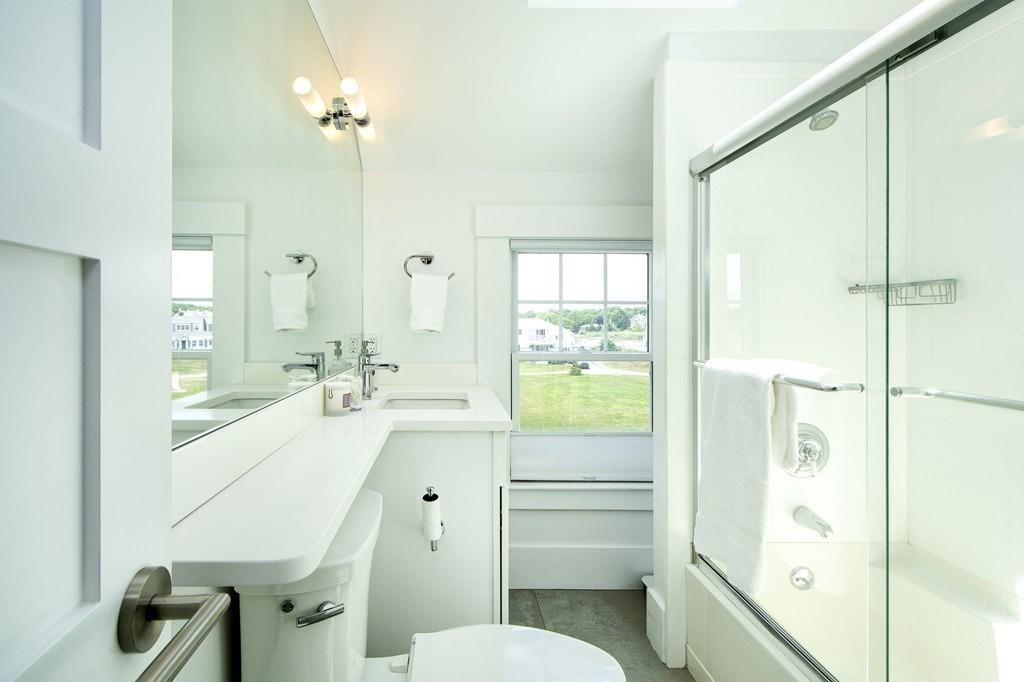 43 Surfside Road Scituate, MA 02066 - Photo 25 of 40 a bathroom with a sink a toilet a mirror and shower