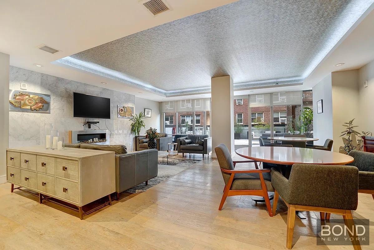 237 East 34th Street, Unit 706 Manhattan, NY 10016 - Photo 20 of 25 a living room with furniture and a flat screen tv