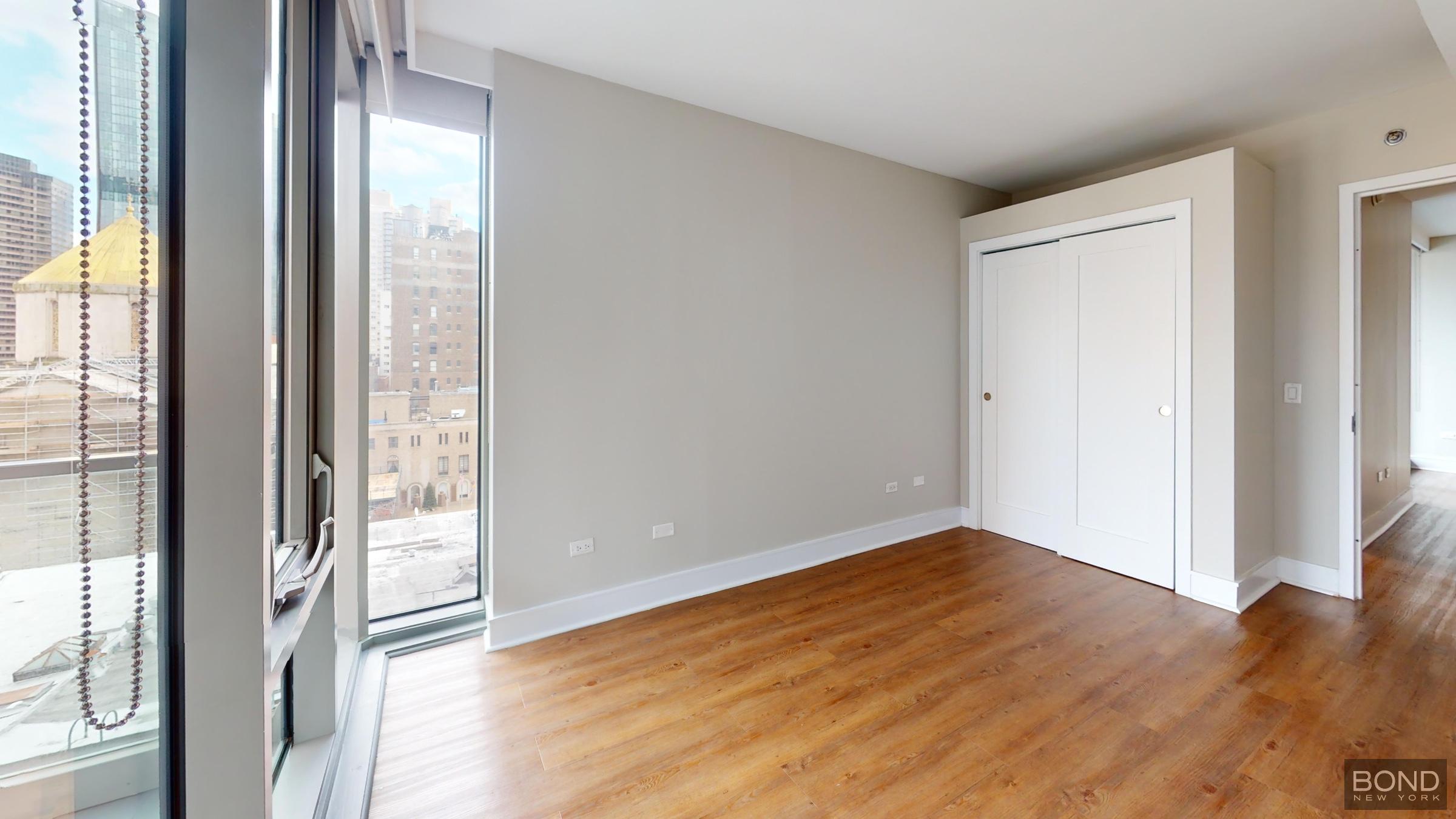 237 East 34th Street, Unit 706 Manhattan, NY 10016 - Photo 9 of 25 a view of an empty room with wooden floor and a window