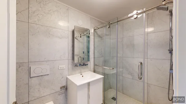 a bathroom with a shower a sink and mirror