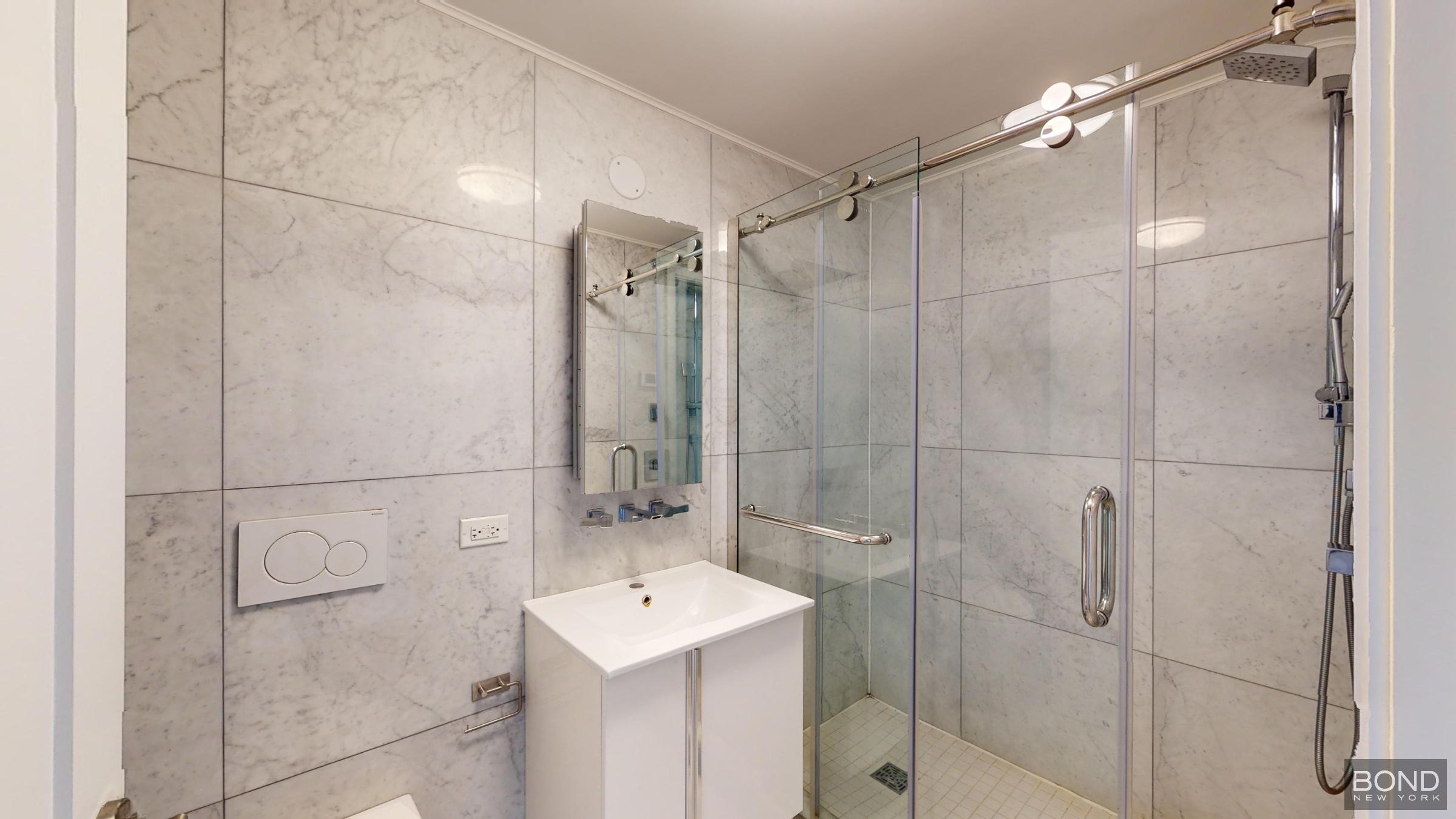 237 East 34th Street, Unit 706 Manhattan, NY 10016 - Photo 10 of 25 a bathroom with a shower a sink and mirror