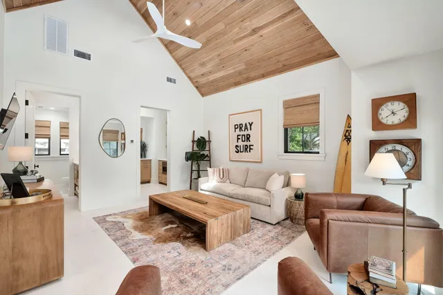 a living room with furniture a flat screen tv and a window