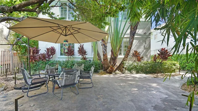 a view of patio with chairs and table under an umbrella
