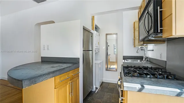 a kitchen with stainless steel appliances granite countertop a stove and a refrigerator