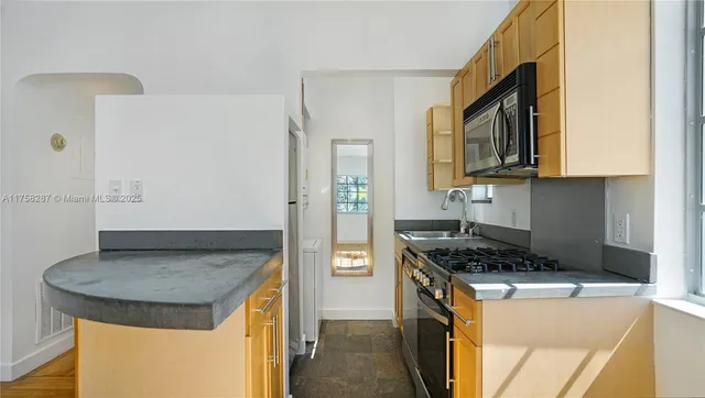 a kitchen with stainless steel appliances granite countertop a stove and a microwave
