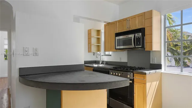 a kitchen with a sink a microwave a stove and refrigerator