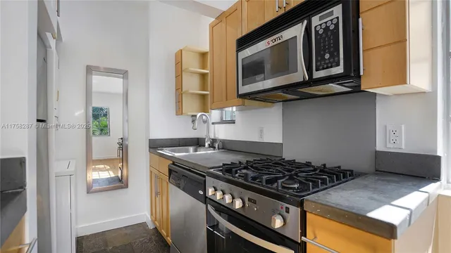 a kitchen with stainless steel appliances granite countertop a stove and a microwave