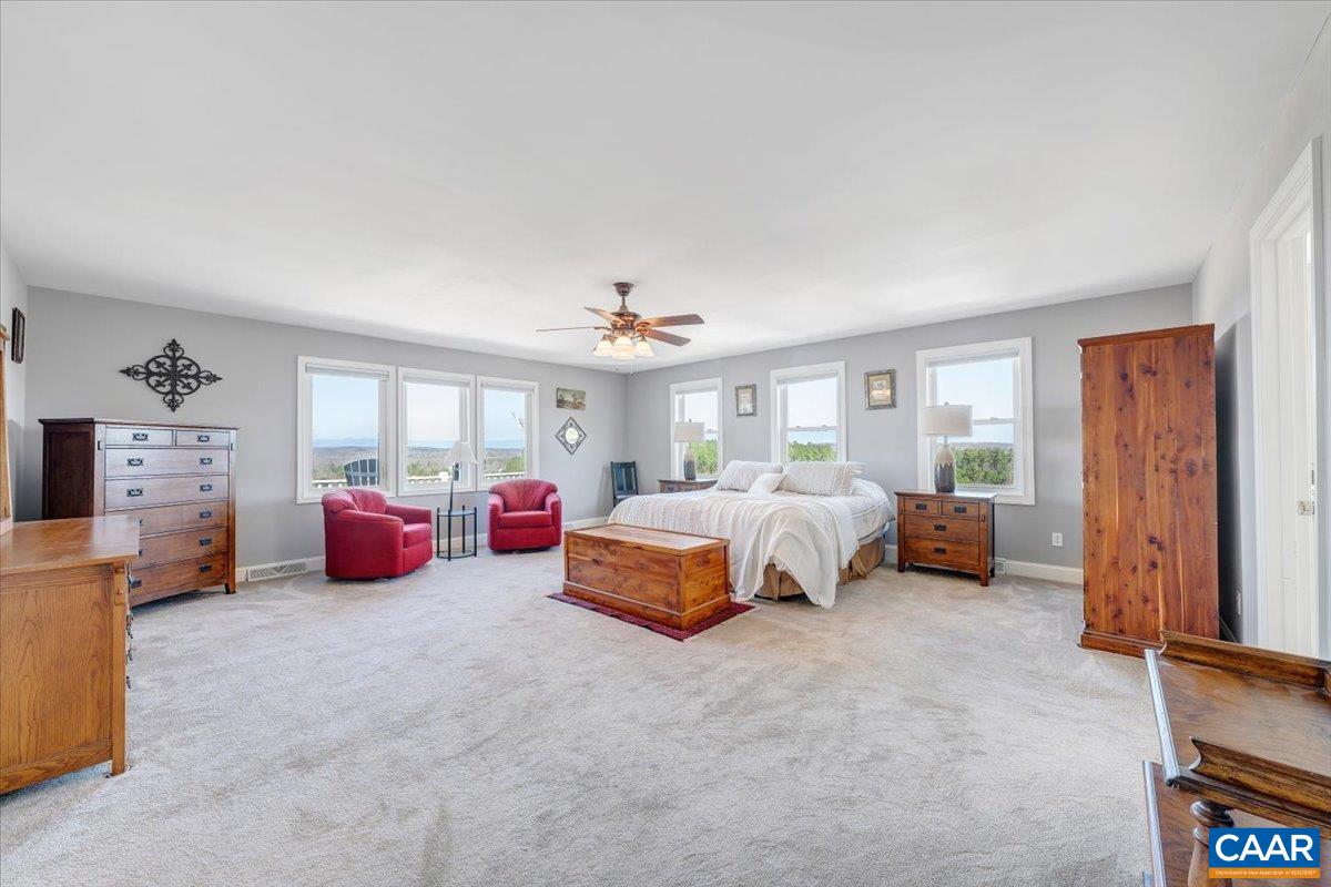 439 Gardner Farm Road Appomattox, VA 24522 - Photo 25 of 73 a spacious bedroom with a bed and a chandelier
