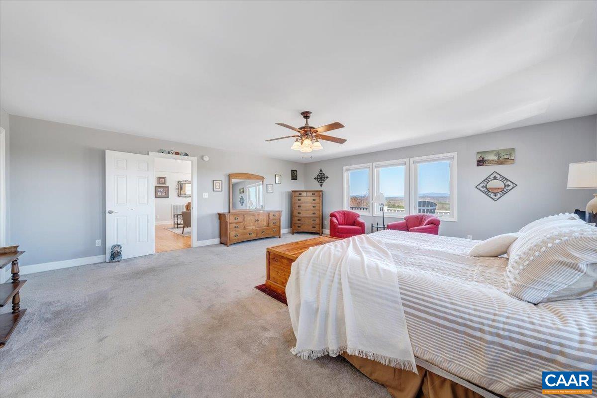 439 Gardner Farm Road Appomattox, VA 24522 - Photo 26 of 73 a bedroom with a large bed and a chandelier