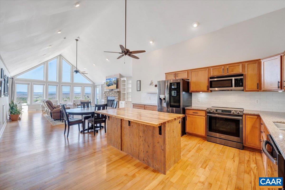 439 Gardner Farm Road Appomattox, VA 24522 - Photo 5 of 73 a kitchen with stainless steel appliances granite countertop a stove top oven a sink a dining table and chairs with wooden floor