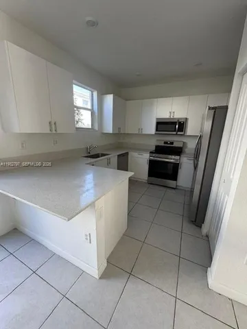 a kitchen with stainless steel appliances a sink stove and cabinets