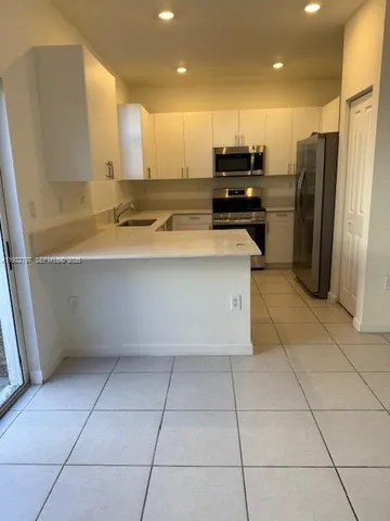 a kitchen with stainless steel appliances granite countertop a refrigerator and a stove
