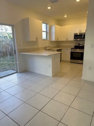 a kitchen with stainless steel appliances granite countertop a sink and a stove