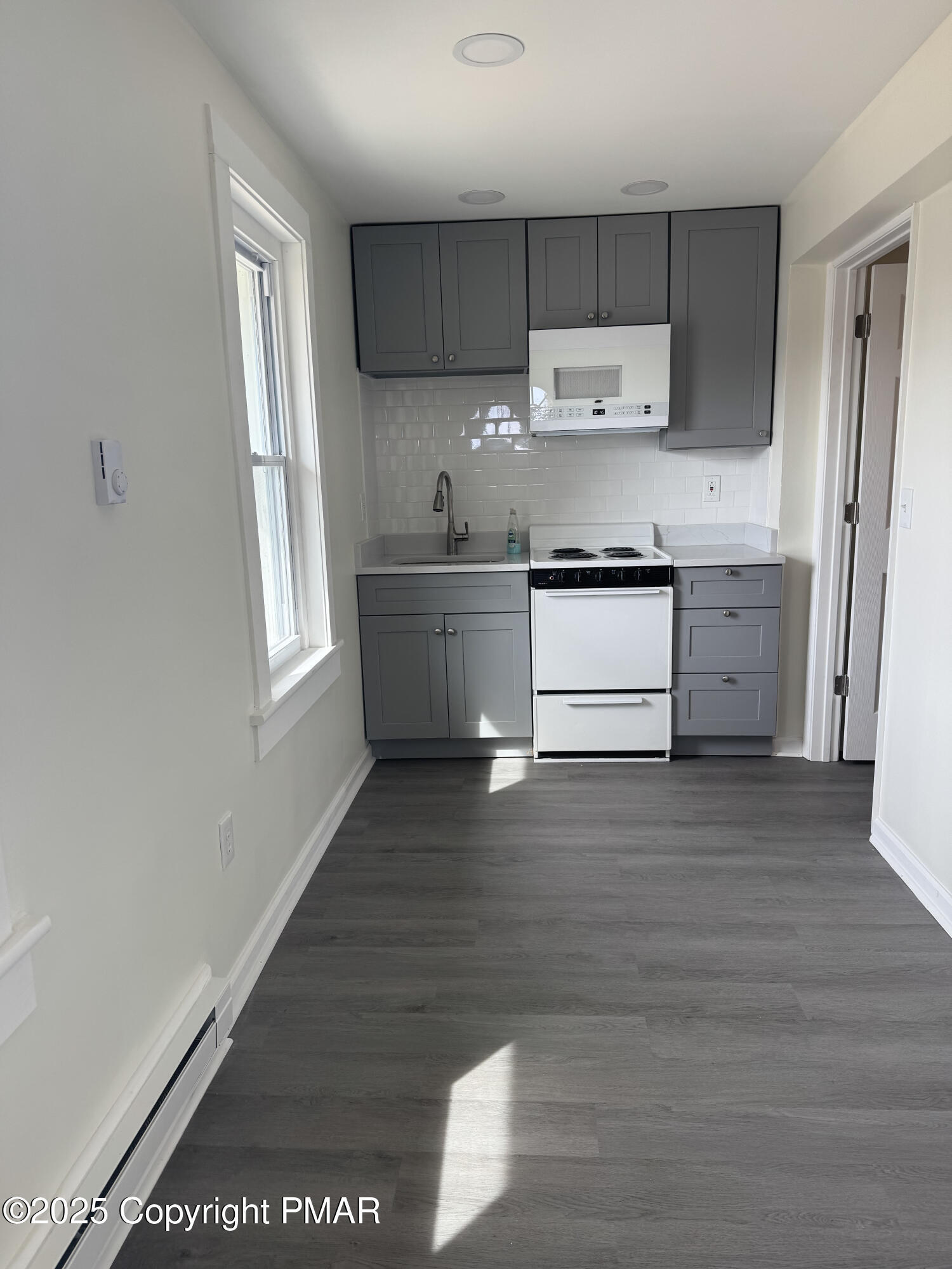 807 Chestnut Street, Unit 2 Coplay, PA 18037 - Photo 8 of 13 a kitchen with a white wooden cabinets and wooden floor