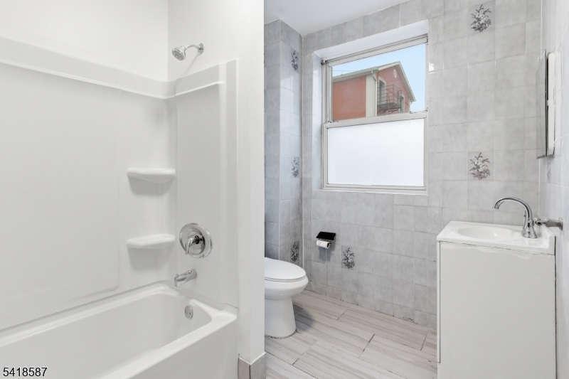 5 Elm Street, Unit 3 Newark, NJ 07102 - Photo 13 of 15 a bath room with a toilet a sink and a bath tub