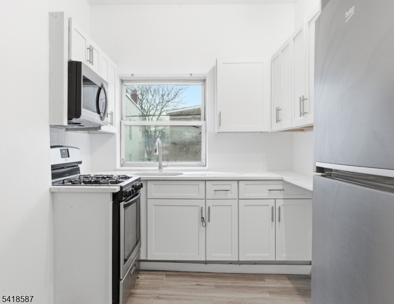 5 Elm Street, Unit 3 Newark, NJ 07102 - Photo 6 of 15 a kitchen with stainless steel appliances granite countertop a stove a sink and a microwave