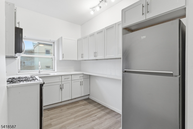 5 Elm Street, Unit 3 Newark, NJ 07102 - Photo 7 of 15 a kitchen with a refrigerator sink and cabinets