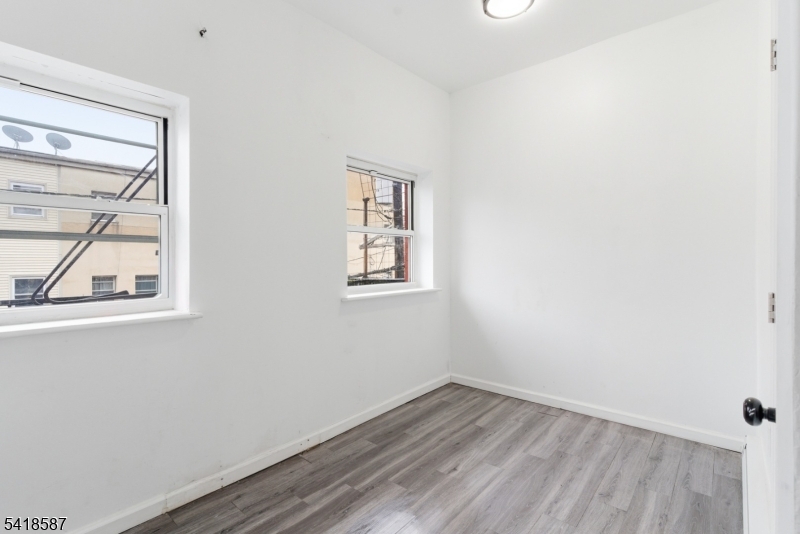 5 Elm Street, Unit 3 Newark, NJ 07102 - Photo 9 of 15 a view of an empty room with wooden floor and a window