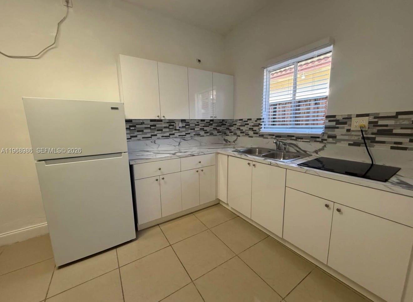 23160 Southwest 113 Passage, Unit 2 Miami, FL 33170 - Photo 4 of 12 a kitchen with a sink a refrigerator and cabinets