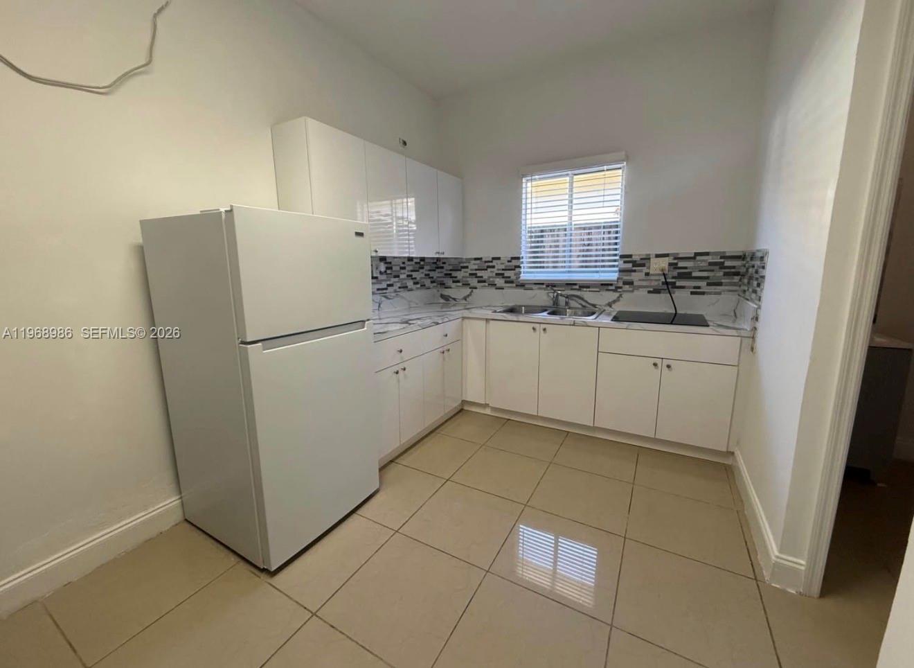 23160 Southwest 113 Passage, Unit 2 Miami, FL 33170 - Photo 5 of 12 a kitchen with a sink a refrigerator and cabinets