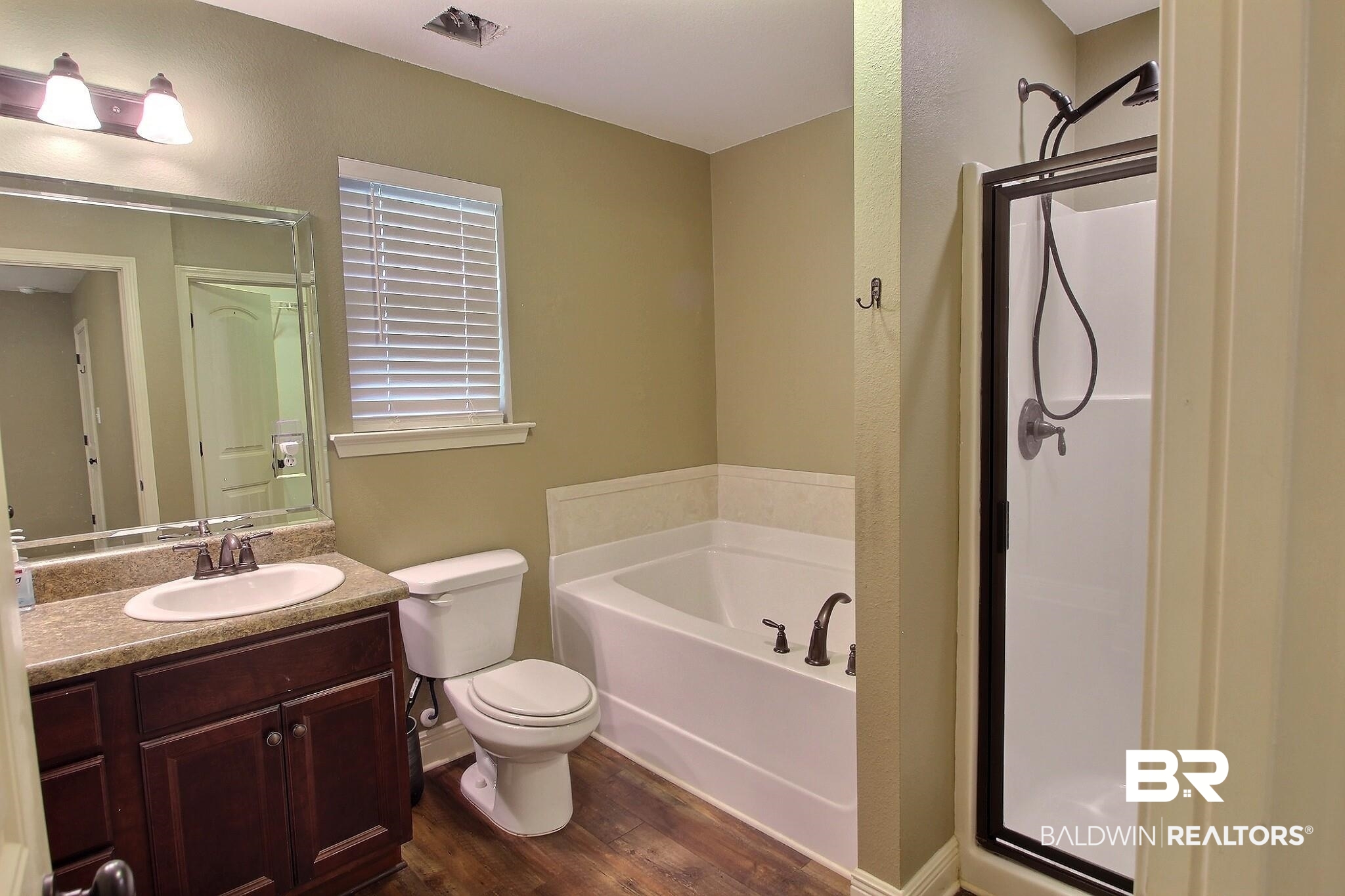 15577 Talus Court Foley, AL 36535 - Photo 16 of 28 Full bath featuring dark wood-type flooring, vanity, a bath, and a stall shower