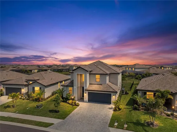 a view of a big house with a big yard and potted plants