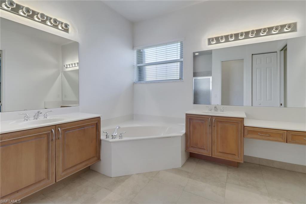 9246 Springview Loop Estero, FL 33928 - Photo 23 of 44 a bathroom with a tub a sink and mirror