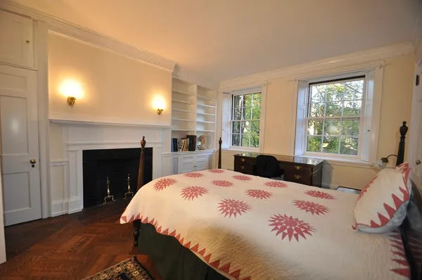 a bedroom with a large bed and a fireplace