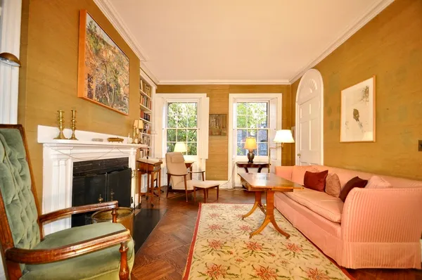 a living room with furniture large window and wooden floor