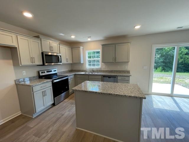4027 Water Wheel Road Rocky Mount, NC 27803 - Photo 3 of 5 a kitchen with granite countertop a stove top oven a sink dishwasher and a refrigerator with wooden floor