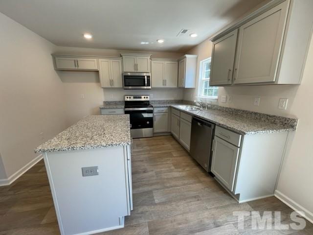 4027 Water Wheel Road Rocky Mount, NC 27803 - Photo 4 of 5 a kitchen with stainless steel appliances granite countertop a stove top oven a sink and dishwasher a refrigerator with wooden floor