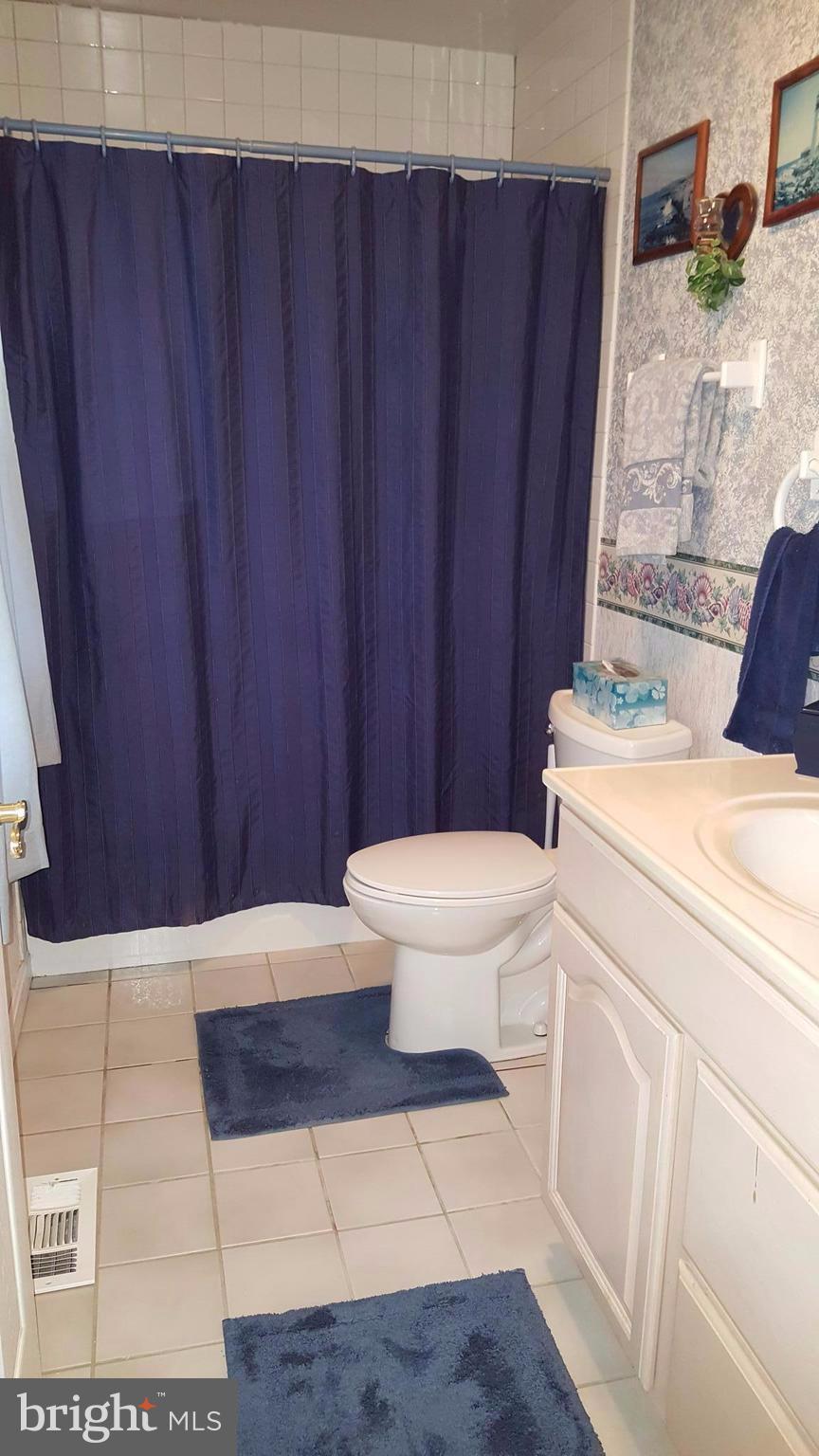 4111 Klausmier Road Baltimore, MD 21236 - Photo 15 of 28 a bathroom with a toilet a sink and curtain