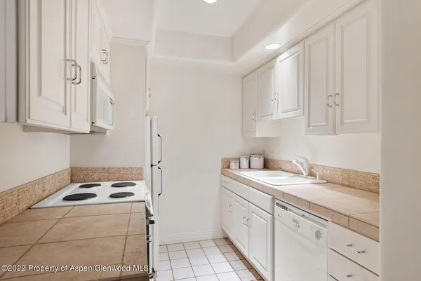a kitchen with sink a stove and cabinets