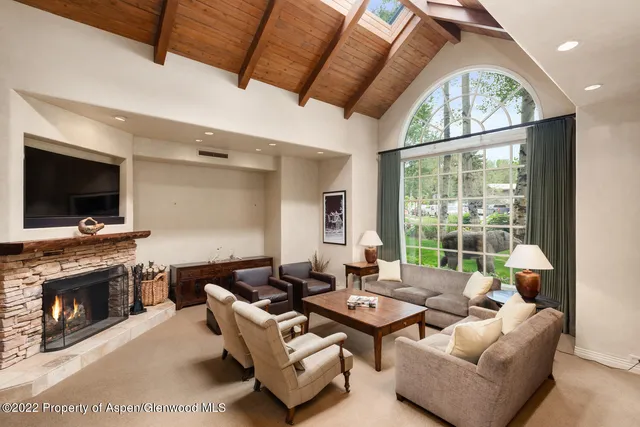 a living room with furniture a flat screen tv and a fireplace