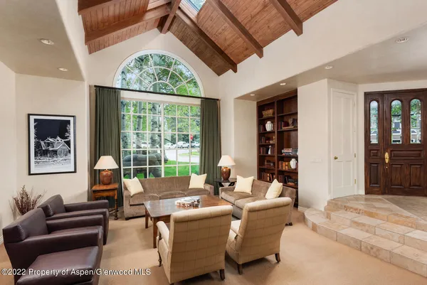 a living room with furniture large window and cabinet