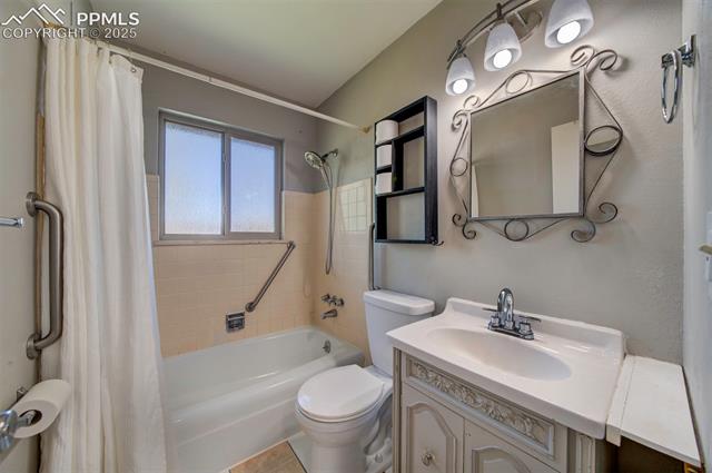 3870 Half Turn Road Colorado Springs, CO 80917 - Photo 24 of 34 Full bathroom featuring toilet, shower / bath combination with curtain, and vanity