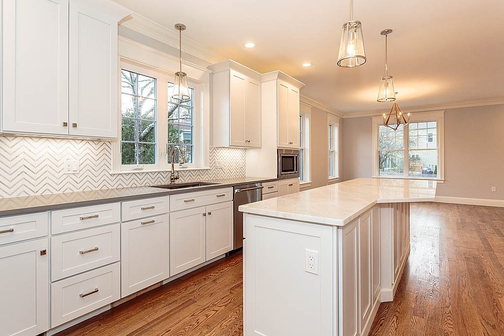 8 Cleveland Road, Unit A Winchester, MA 01890 - Photo 1 of 26 a large kitchen with kitchen island white cabinets and wooden floor