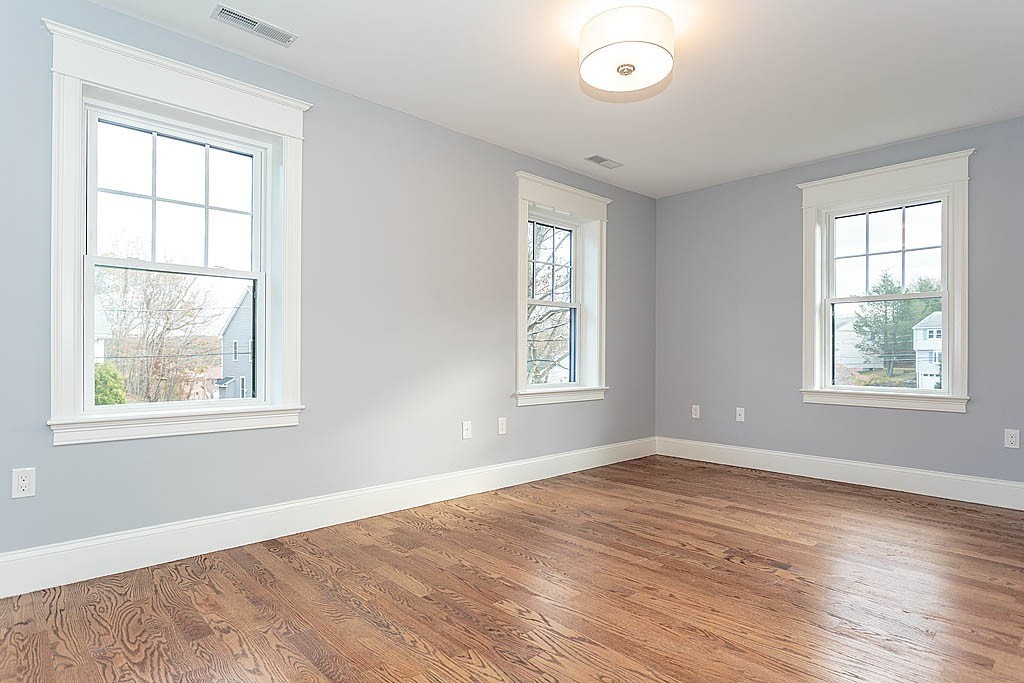 8 Cleveland Road, Unit A Winchester, MA 01890 - Photo 19 of 26 an empty room with wooden floor and windows
