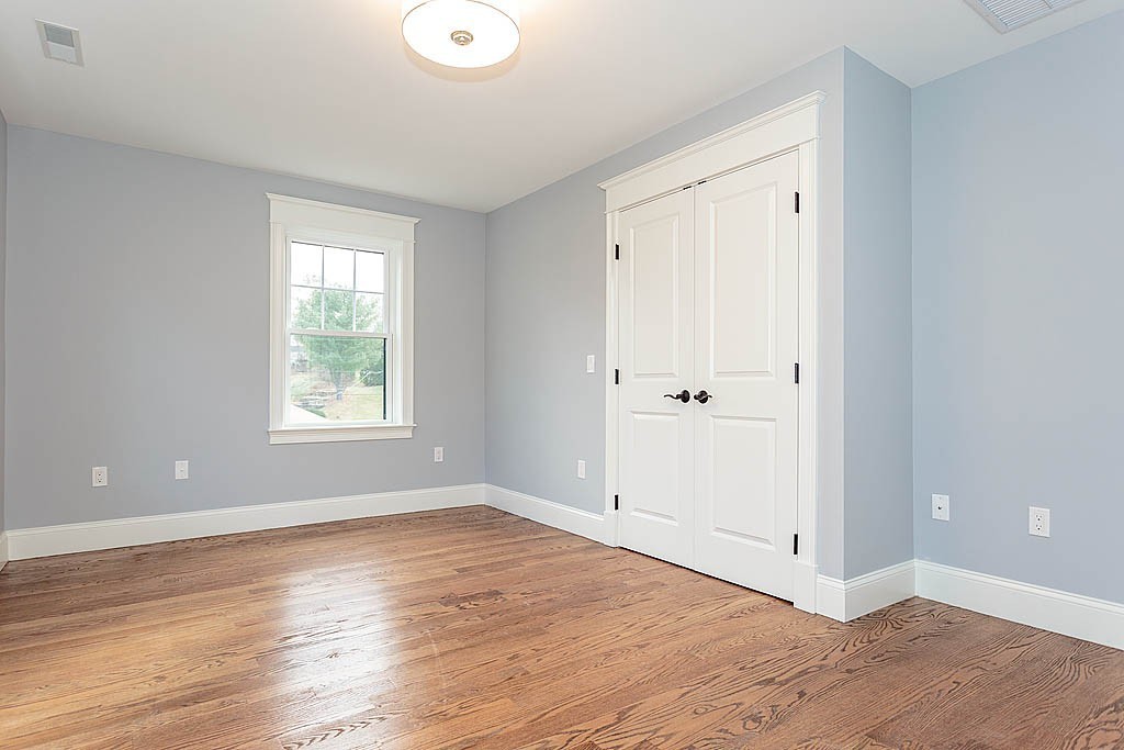 8 Cleveland Road, Unit A Winchester, MA 01890 - Photo 20 of 26 a view of an empty room with wooden floor and a window