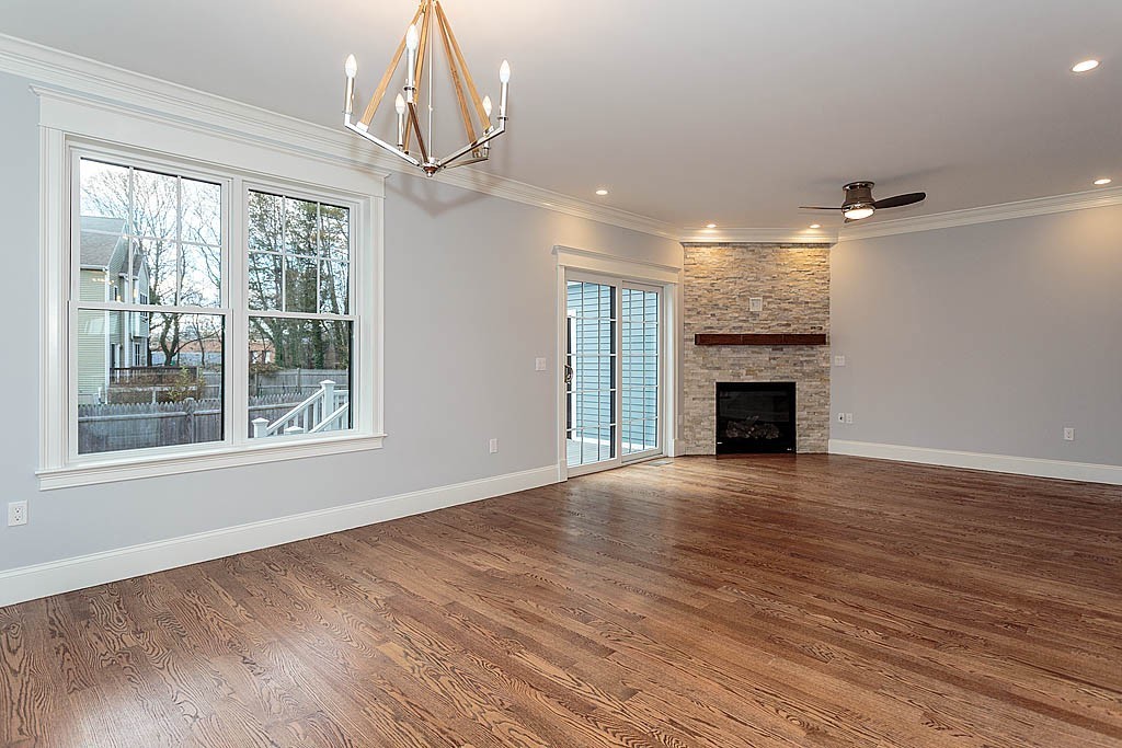 8 Cleveland Road, Unit A Winchester, MA 01890 - Photo 8 of 26 a view of an empty room with wooden floor fireplace and a window