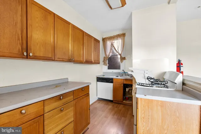 a kitchen with stainless steel appliances a stove a sink wooden cabinets and a refrigerator