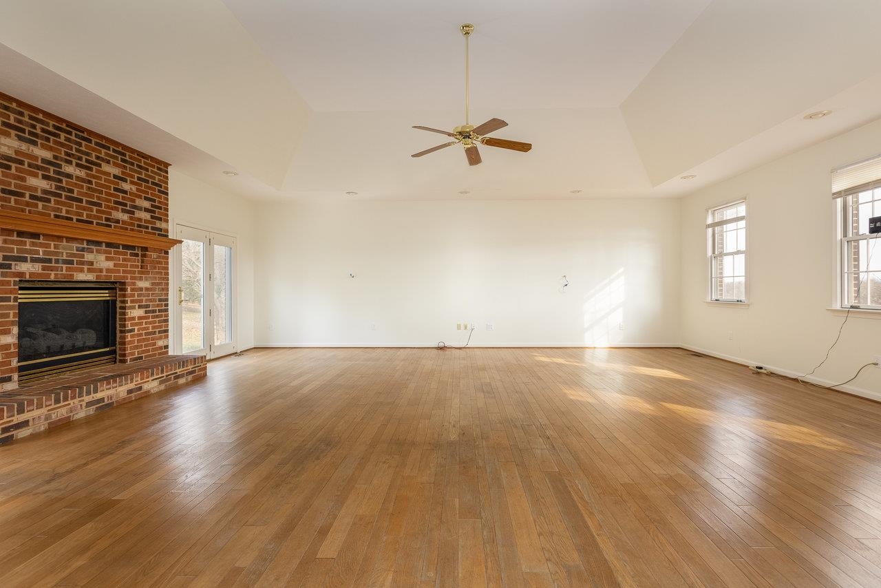 7664 Kiser Road Mount Crawford, VA 22841 - Photo 15 of 45 an empty room with wooden floor fireplace and windows