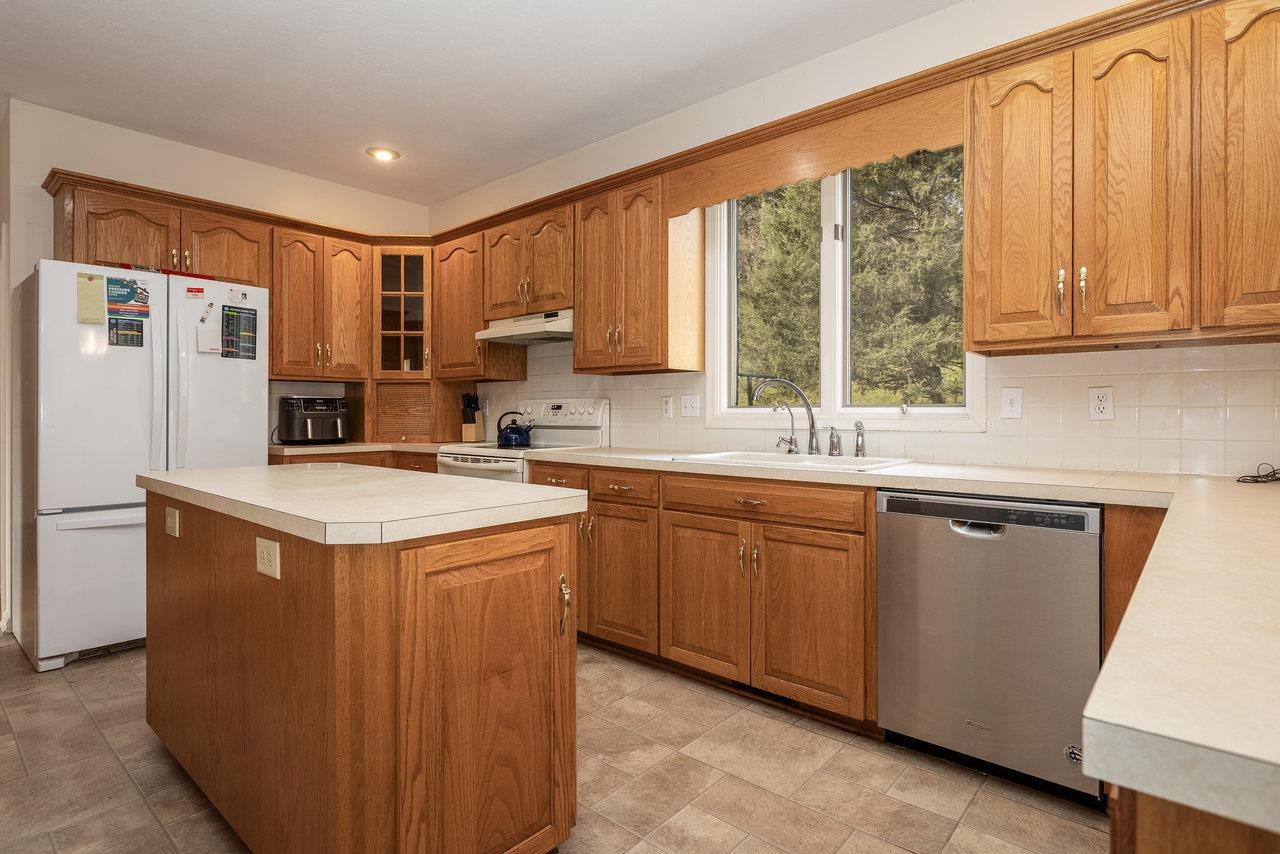 7664 Kiser Road Mount Crawford, VA 22841 - Photo 10 of 45 a kitchen with stainless steel appliances granite countertop a refrigerator a sink dishwasher a stove and white countertops with wooden floor